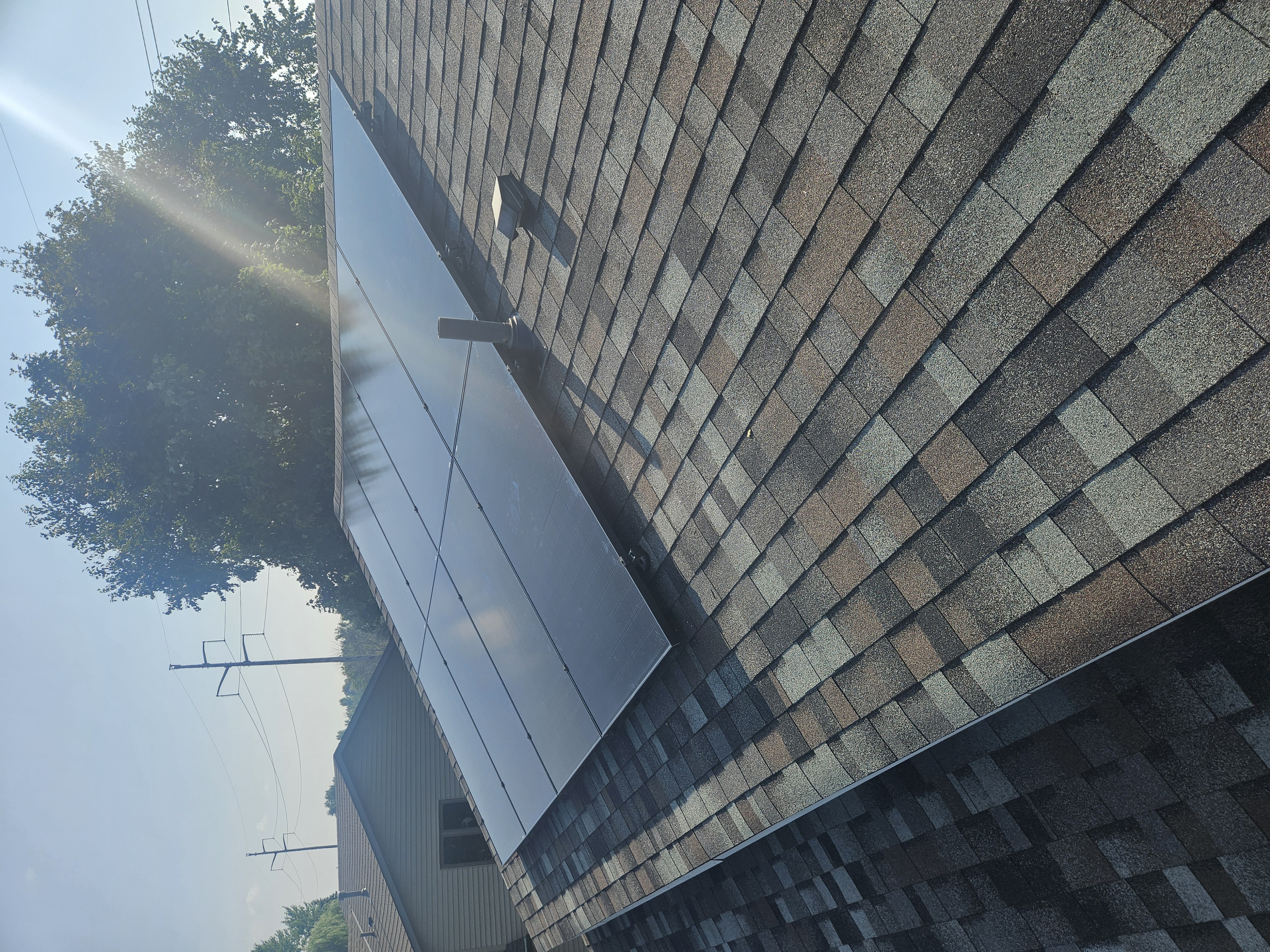 Solar panels installed at an angle on a shingled roof